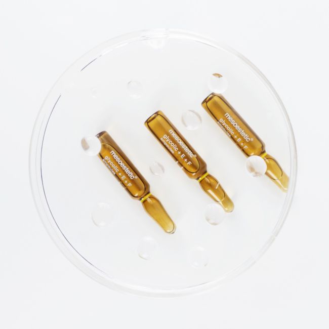 Three amber-colored ampoules on a white background.