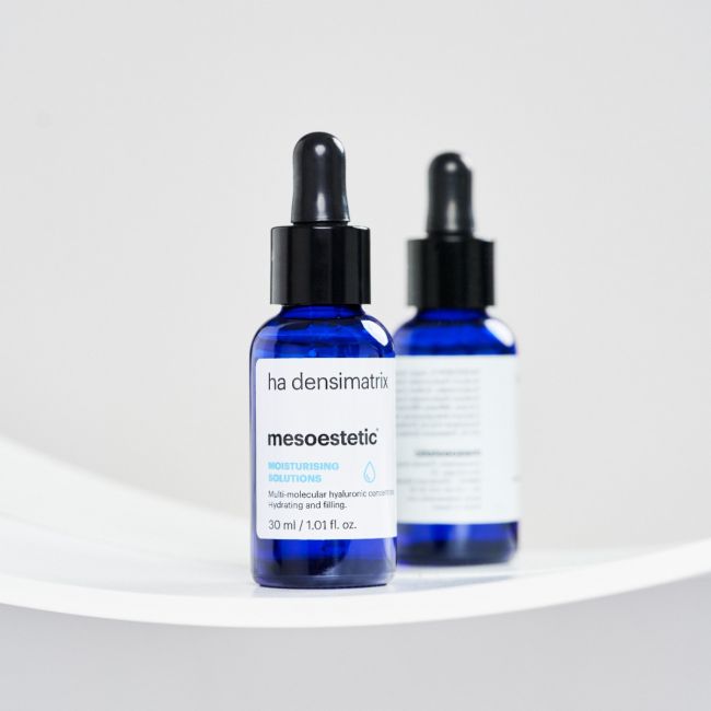 Two blue skincare serum bottles with droppers on a white background