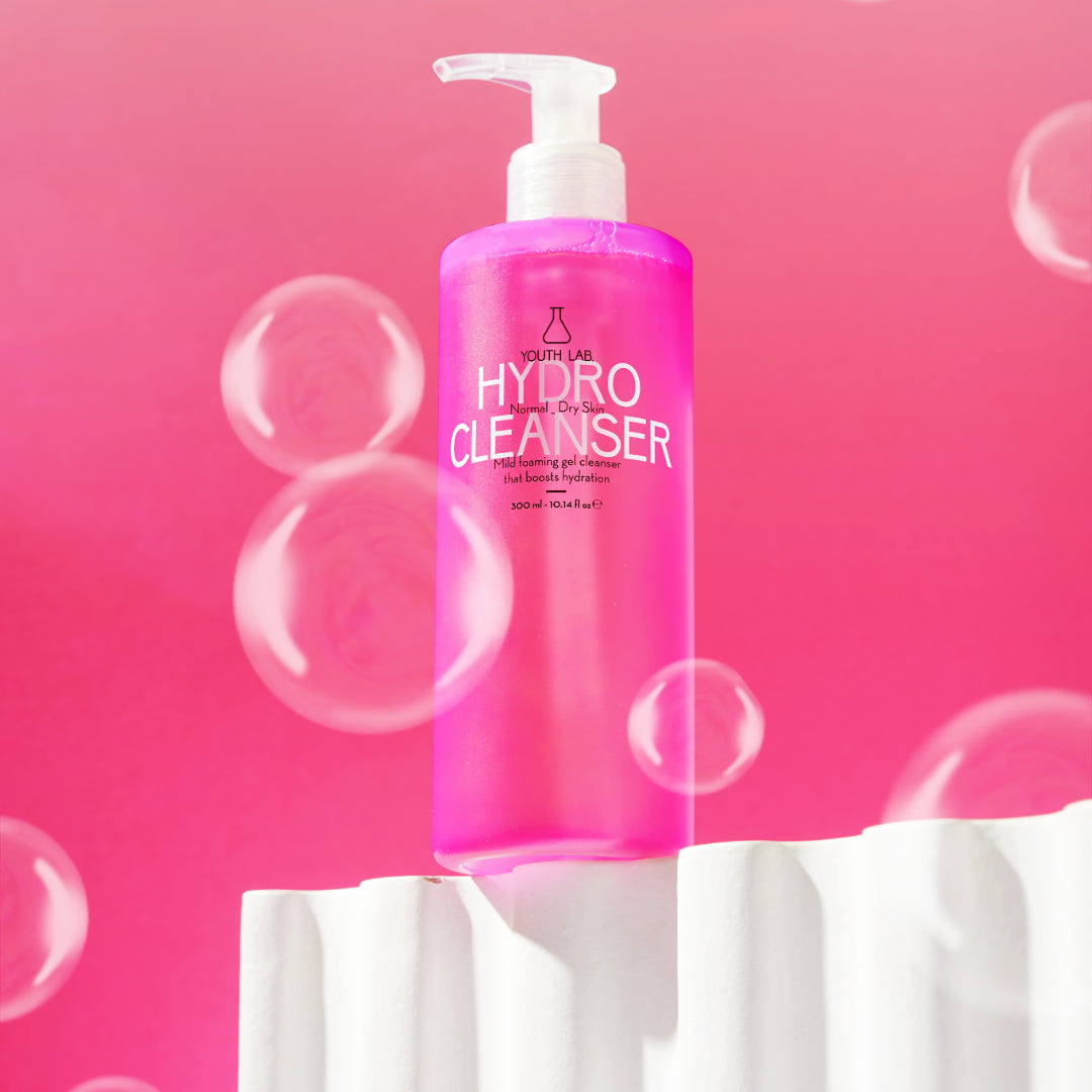 Foamy texture of cleanser on hand with water droplets