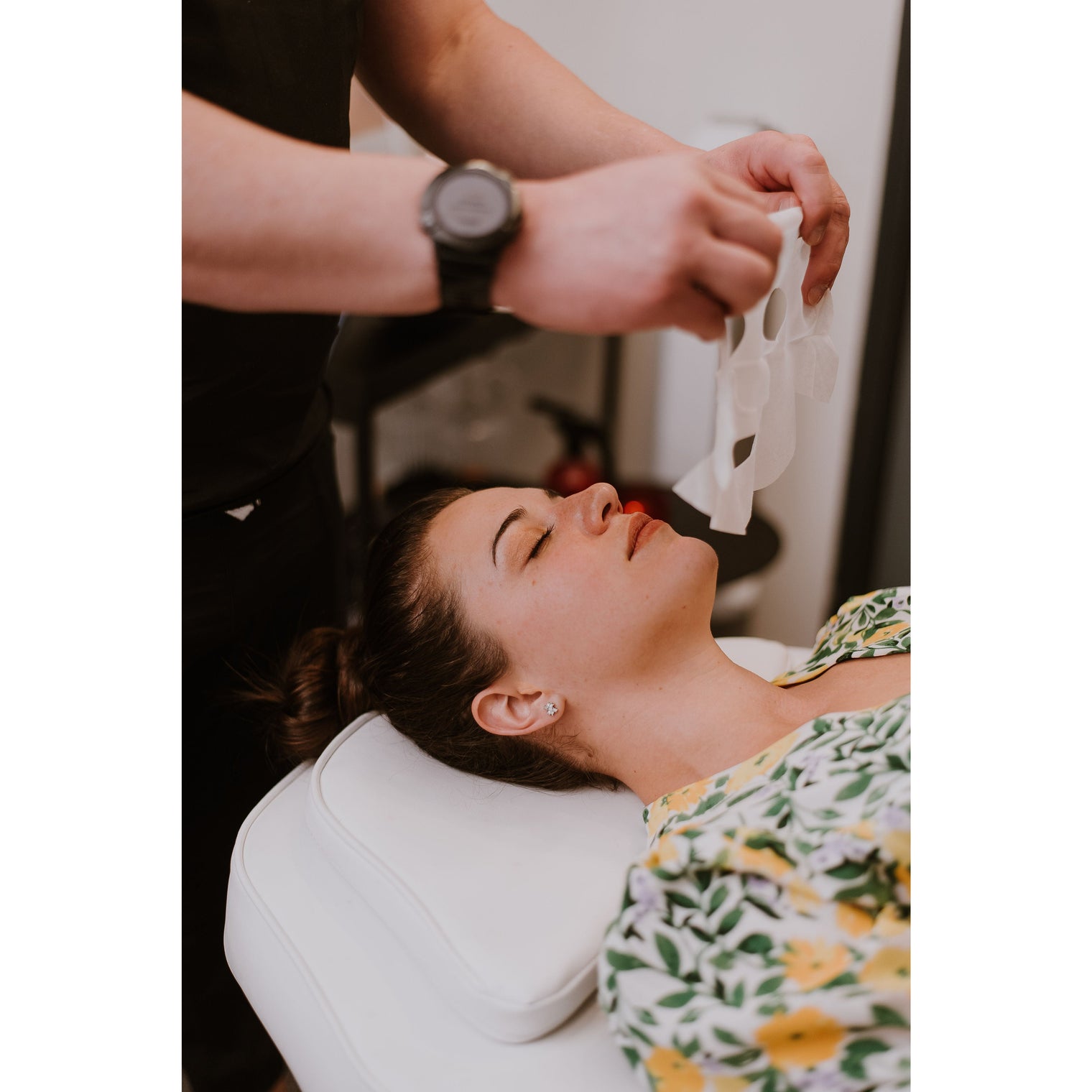 Woman applying a single-use sheet mask infused with potent actives, including growth factors, hyaluronic acid, aloe vera, and arbutin, for intense hydration, age correction, and post-inflammatory pigmentation prevention.