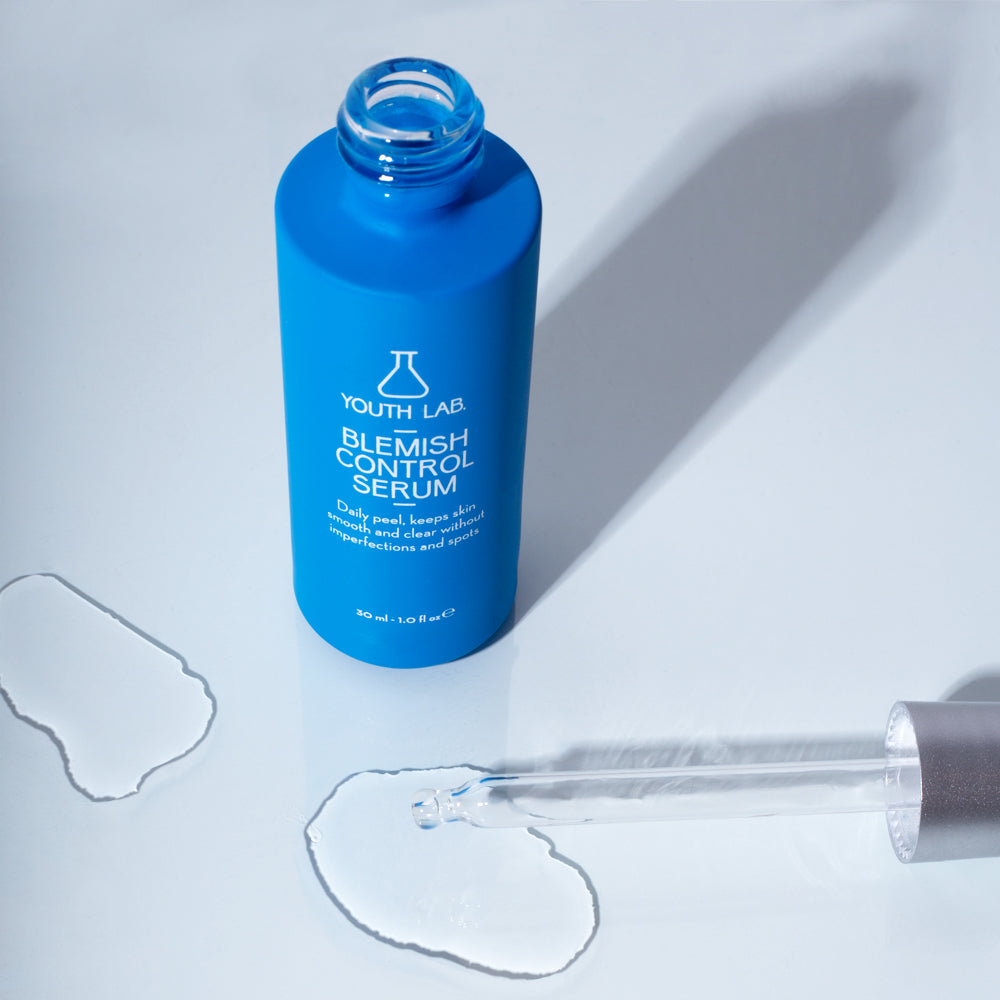 Clear dropper applying serum to skin to treat breakouts and refine texture