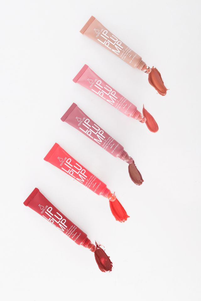 Five lip gloss tubes with visible gloss on a white background